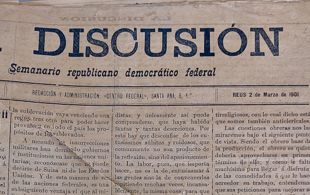 Gelblicher Zeitungsausschnitt mit schwarzer Tinte, Überschrift "Semanario Repúblicano Democrático Federal", mit dem Wort "Diskussion", leicht zerknittert mit sichtbaren Handhabungsspuren.