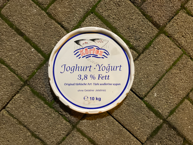 Ein Teller Joghurt mit Text darauf, der auf einem Ziegelsteinweg steht.