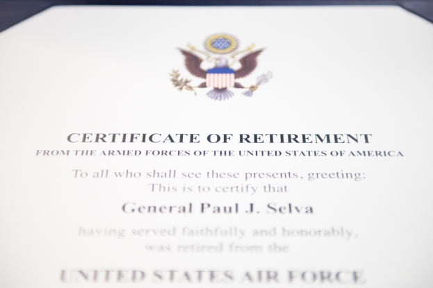Rahmenurkunde für den Ruhestand der United States Air Force mit blauem Rand, schwarzem Text und einem zentralen Schild-Logo mit einem Stern, einem Lorbeerkranz und einer 'Ruhestand'-Bannerschrift.