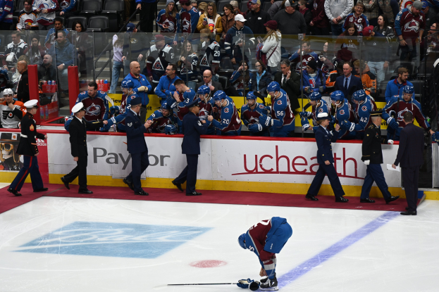 Eishockeyspieler auf dem Eis umgeben von Fans und Offiziellen während eines Spiels zwischen Colorado Avalanche und San Jose Sharks am 24. März 2015.