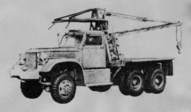 Schwarzes und weißes Foto eines großen, vierrädrigen Lastwagen mit einem Kran auf dem Rücken und einem flachen Anhänger, der als erstes Schwerlastfahrzeug gilt.