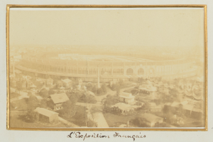 Alte Fotografie eines Stadions in städtischer Umgebung mit umliegenden Gebäuden, Bäumen und Strommasten, mit Text unten.