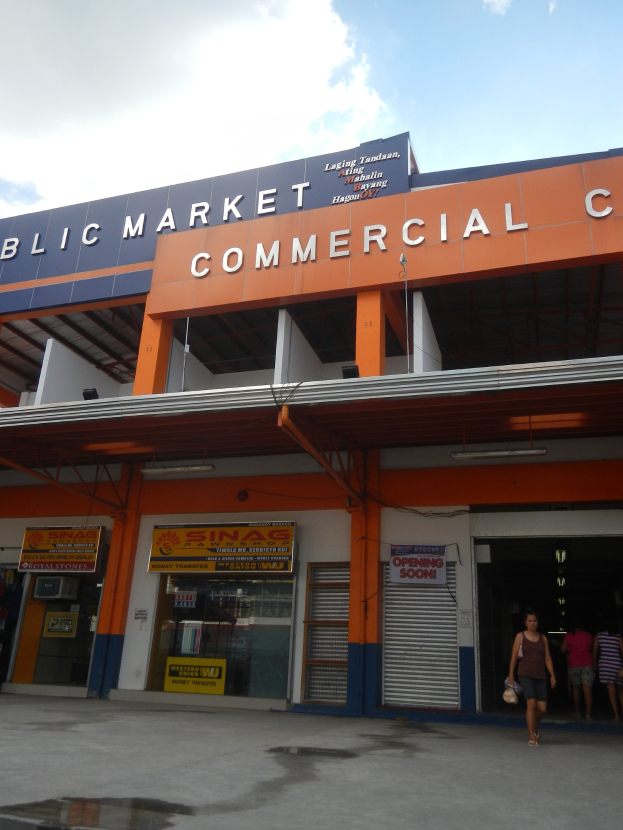 Öffentlicher Markt mit Menschen vor einem Geschäftshaus, Text auf dem Gebäude und Himmel oben