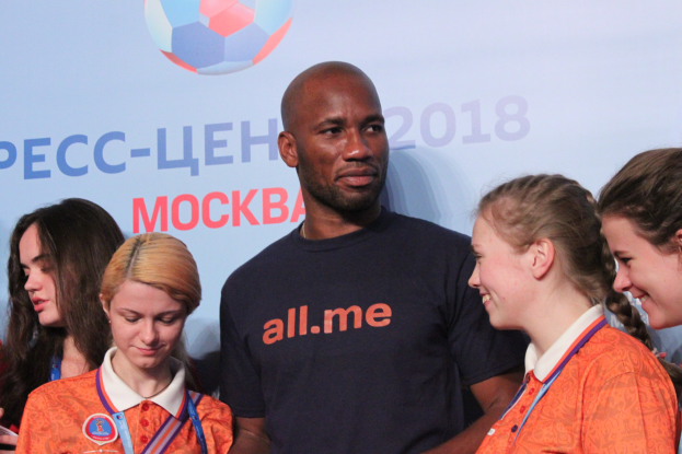 Gruppe von Menschen auf einer Bühne mit Medaillen, im Hintergrund ein Banner der FIFA-Weltmeisterschaft 2018 mit einem Fußball.