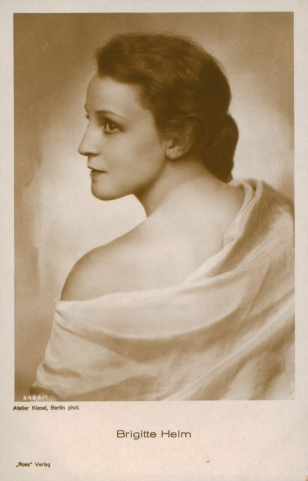 Schwarz-weiß-Porträt von Brigitte Helm in einem weißen Kleid mit Text unten.