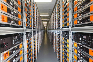 Eine lange Reihe von Servern in einem Rechenzentrum, mit elektronischen Geräten in den Racks und Lampen oben.