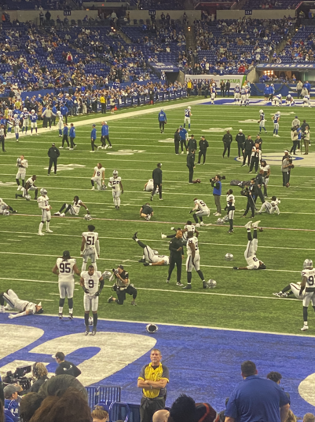 Ein Fußballspiel wird in einem Stadion mit Zuschauern und einer Person mit einer Kamera gespielt.